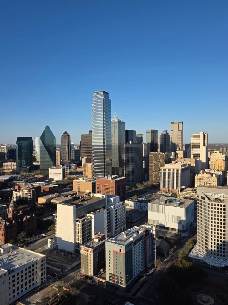 Skyline de Dallas con sus edificios icónicos bajo cielo azul - guía del recién llegado al Metroplex para comprar carro y registrarlo