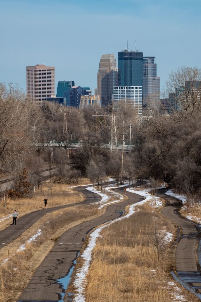 Sendero de invierno en Minneapolis con el skyline de fondo - guía del recién llegado: placas que se quedan con el carro, impuesto de $10 y nieve de emergencia